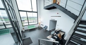 Tips for Transitioning Your Business Away From eFax A woman working at a stylish office desk, surrounded by modern tools showing a professional space